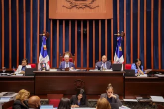 El ministro de Justicia tendrá como principales atribuciones coordinar las políticas públicas contra la criminalidad, gestionar la colaboración del Poder Ejecutivo con el sistema judicial, representar y defender al Estado en sedes jurisdiccionales y foros arbitrales, así como coordinar el Sistema Nacional de Derechos Humanos y dar respuesta a los requerimientos de organismos internacionales en esta materia. La aprobación de esta ley representa un paso trascendental en el proceso de modernización institucional del país, y responde a la necesidad de contar con un ente especializado que coordine los esfuerzos del Estado en materia judicial, penitenciaria y de derechos humanos. En los trabajos legislativos de este miércoles, el Pleno del Senado aprobó las modificaciones al proyecto de ley que modifica la Ley núm. 225-20, Ley General de Gestión Integral y Coprocesamiento de Residuos Sólidos, iniciativa presentada por los senadores Ramón Rogelio Genao Durán y Ginnette Bournigal de Jiménez. La iniciativa legislativa busca modificar la Ley núm. 225-20 para fortalecer el marco normativo que regula la gestión integral y sostenible de los residuos sólidos en el país. Con esta ley se promueve la reducción, reutilización, reciclaje y aprovechamiento de residuos, así como una mejor regulación de su recolección y disposición, con el fin de proteger la salud, el medio ambiente y reducir los gases de efecto invernadero. La modificación de esta ley considera necesario alinear su contenido con los objetivos de reducción del impacto ambiental de los residuos, mediante la implementación de regulaciones más estrictas sobre el uso de materiales no biodegradables y la promoción del empleo de materiales reciclados y biodegradables. También se aprobó la ley que modifica los artículos 36, 64 y 81 de la Ley núm. 176-07, que regula el Distrito Nacional y los Municipios, con el objetivo de establecer disposiciones más claras sobre la sucesión en los cargos de alcaldes, vicealcaldes, regidores, directores, suplentes de directores y vocales de las juntas de distritos municipales. Esta iniciativa legislativa fue presentada por la senadora María Mercedes Ortiz Diloné. Entre las modificaciones introducidas por la ley, se destaca el artículo 64, relativo a la sustitución del alcalde o alcaldesa. Este establece que la vacante definitiva en el cargo de alcalde o alcaldesa será ocupada por el vicealcalde o vicealcaldesa, quien deberá prestar juramento ante el Concejo de Regidores. El presidente del Concejo de Regidores convocará una sesión extraordinaria al efecto dentro de los quince días hábiles siguientes a la ocurrencia de la vacante. Durante la sesión de este miércoles, además, el Pleno aprobó el proyecto de ley que busca elevar a la categoría de municipio al distrito municipal turístico Verón–Punta Cana, perteneciente actualmente al municipio de Higüey, provincia La Altagracia, presentada por el senador Rafael Barón Duluc Rijo. La iniciativa establece que Verón–Punta Cana ha registrado importantes transformaciones urbanas y socioeconómicas en los últimos años, lo que justifica una nueva organización política y administrativa. Entre los indicadores de su desarrollo se destacan la presencia de más de setenta hoteles, un aeropuerto internacional, un helipuerto y un robusto tejido empresarial que impulsa una de las principales actividades turísticas del país. RESOLUCIONES Los senadores aprobaron varias resoluciones, entre ellas la que solicita al presidente Luis Abinader, instruir al órgano correspondiente con el fin de construir un play de béisbol en el distrito municipal Santiago oeste, del municipio Santiago de los caballeros, provincia Santiago, iniciativa del senador Daniel Enrique de Jesús Rivera. También fue aprobada la resolución que solicita al presidente Luis Abinader instruir al órgano correspondiente con el fin de construir un polideportivo techado en el distrito municipal El Limón, municipio villa González, provincia Santiago, presentada por el senador Daniel Enrique de Jesús Rivera. Los senadores también aprobaron la resolución que reconoce a la cooperativa La Altagracia, en ocasión de su 72 aniversario, iniciativa presentada por los senadores Julito Fulcar Encarnación y Daniel Enrique de Jesús Rivera. Además, los senadores conocieron la resolución que reconoce al destacado músico, productor, compositor, cantante y arreglista, el maestro Henry Hierro, por su trascendental y fecunda labor artística y social en beneficio de la nación dominicana, iniciativa del senador Franklin Martín Romero Morillo. El Pleno también aprobó la ratificación del nombramiento diplomático de Iris Joseline Pujol Rodríguez, como embajadora extraordinaria y plenipotenciaria, concurrente, de la República Dominicana en Ucrania, con sede en la República Federal de Alemania, iniciativa del Poder Ejecutivo.