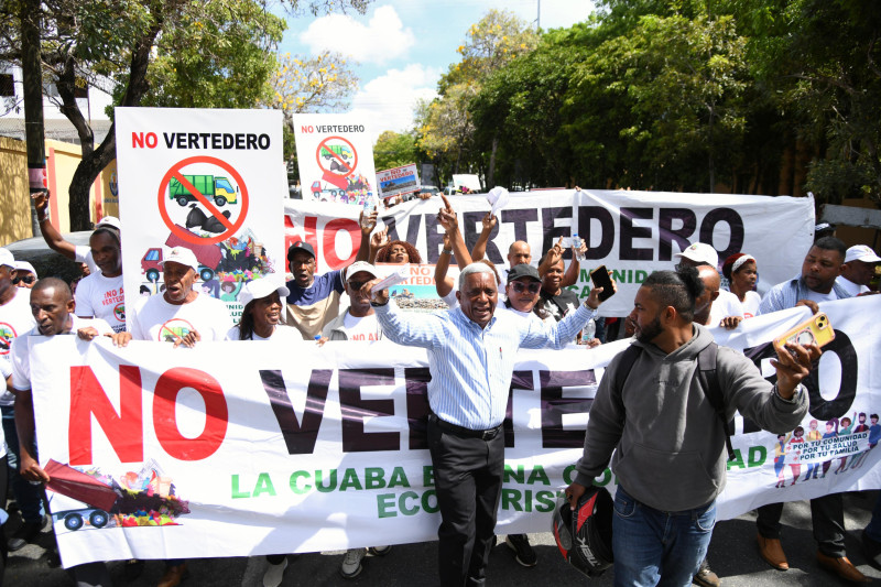 **Comunitarios de La Cuaba protestan frente al Palacio Nacional contra instalación de relleno sanitario** Residentes del distrito municipal La Cuaba realizaron una protesta frente al Palacio Nacional en rechazo a la posible instalación de un relleno sanitario en su comunidad. Los manifestantes aseguran que el proyecto representaría un grave impacto ambiental, económico y social, al afectar fuentes acuíferas, la fauna y la flora de la zona. Durante la manifestación, el vocero del movimiento “No Vertedero La Cuaba”, Fabio Correa, pidió al presidente Luis Abinader la paralización del proyecto, alegando que la comunidad depende del ecoturismo como principal actividad económica. Los comunitarios también denunciaron supuestos intentos de intimidación por parte de personas vinculadas a la empresa responsable de la obra y reiteraron que mantendrán su oposición hasta lograr su cancelación. Más información en alodigitalrd.com. #LaCuaba #RellenoSanitario #Protesta #MedioAmbiente #Comunitarios #AloRD #AloDigitalRD #NoticiasRD